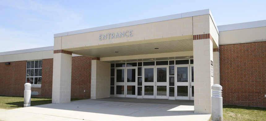 The entrance of a school building, taken on a sunny day.